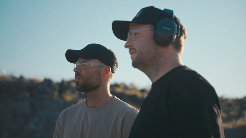 Josh Janssen and Tommy Jackett wearing eye and ear protection at a desert shooting range outside Las Vegas